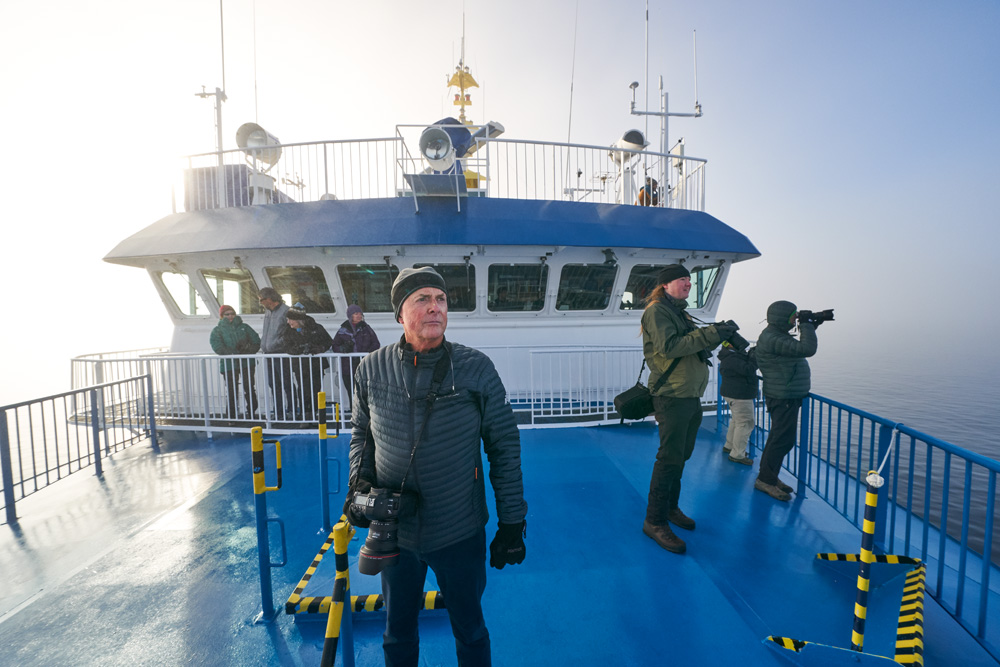Art Wolfe on the bow of the ship hunting for Fog Bows