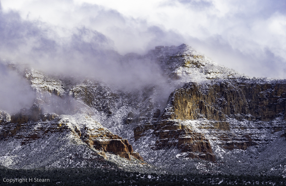 Snow and low clouds blanket red rocks in West Sedona