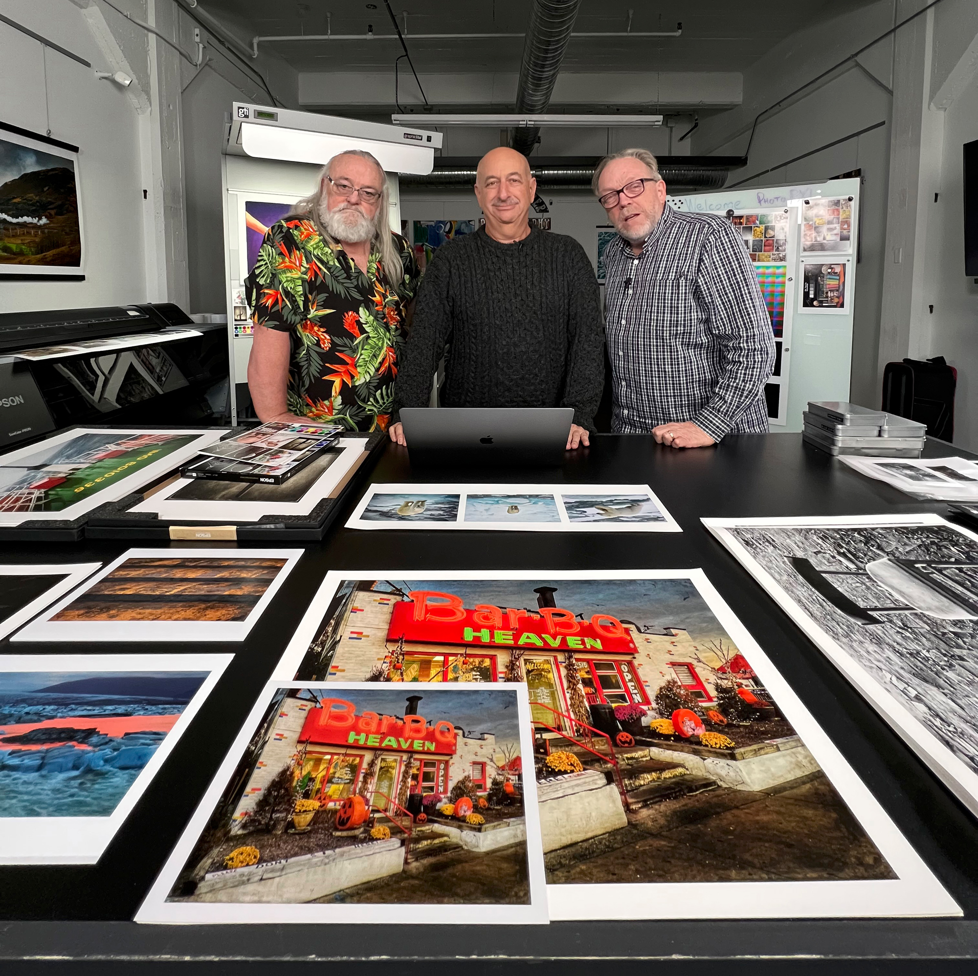 Jeff Schewe, Dan Steinhardt, and Kevin Raber in front of a table full of prints