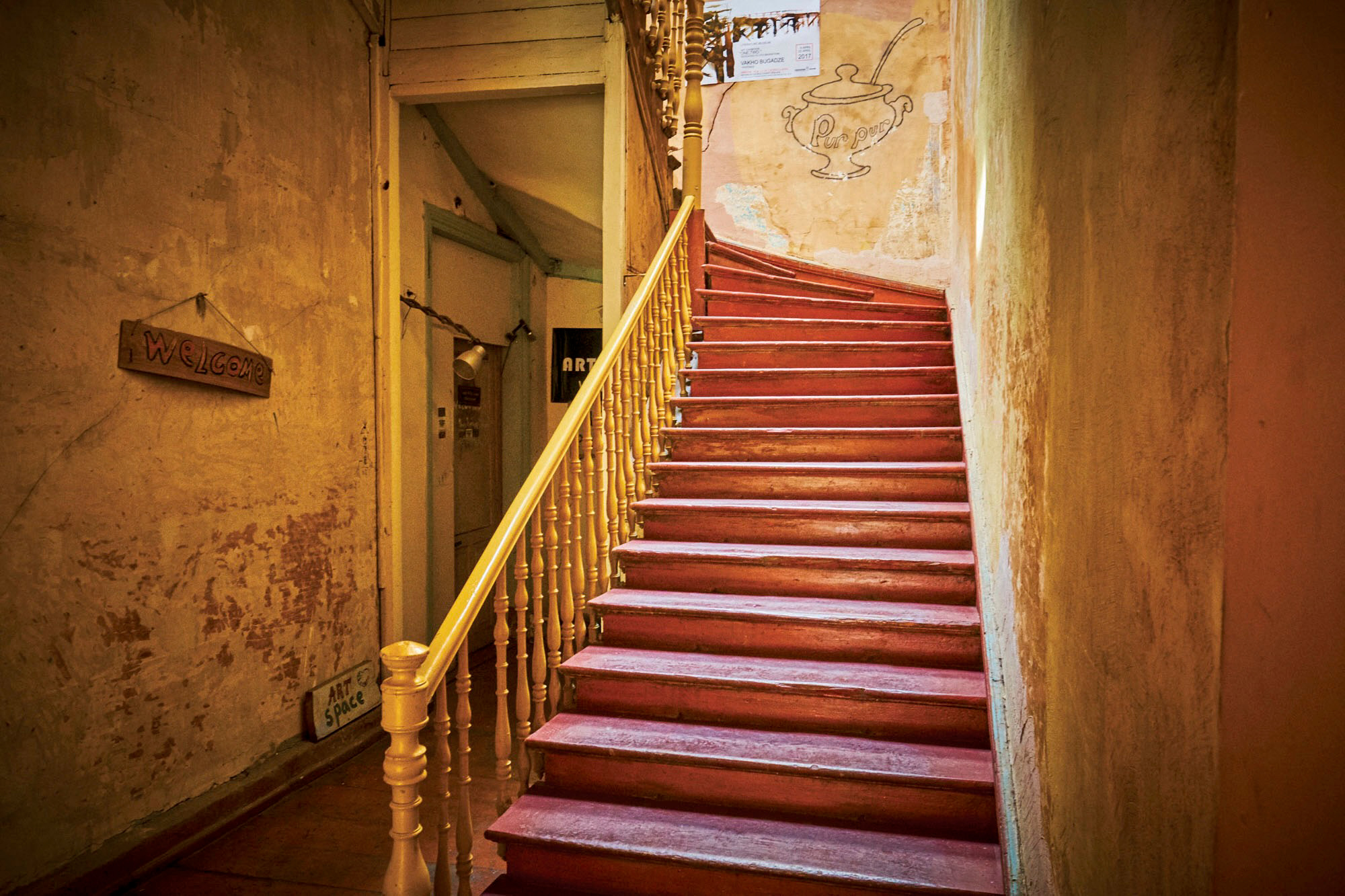 The standard eye-level view of the staircase includes lots of surrounding distractions, whereas the view looking back down from the top of the staircase is contained with fewer distractions and much stronger compositionally.